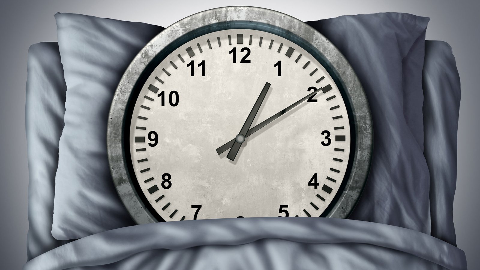 A gray clock pointing at 1 am/pm on top of a bed